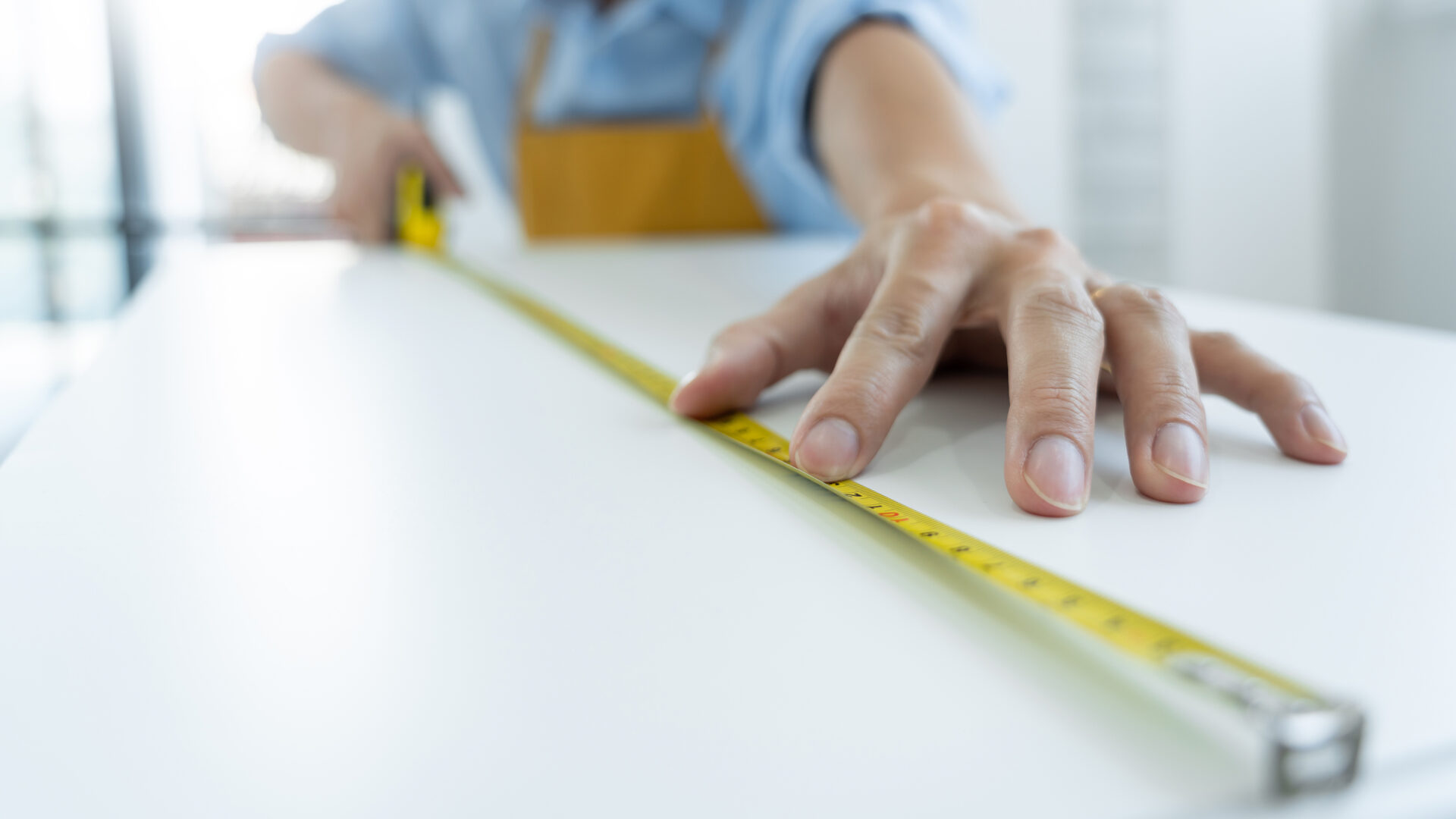 man's hand holding a tape measure