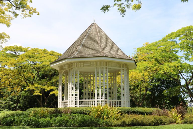 white wooden shed in the middle of the park during day time