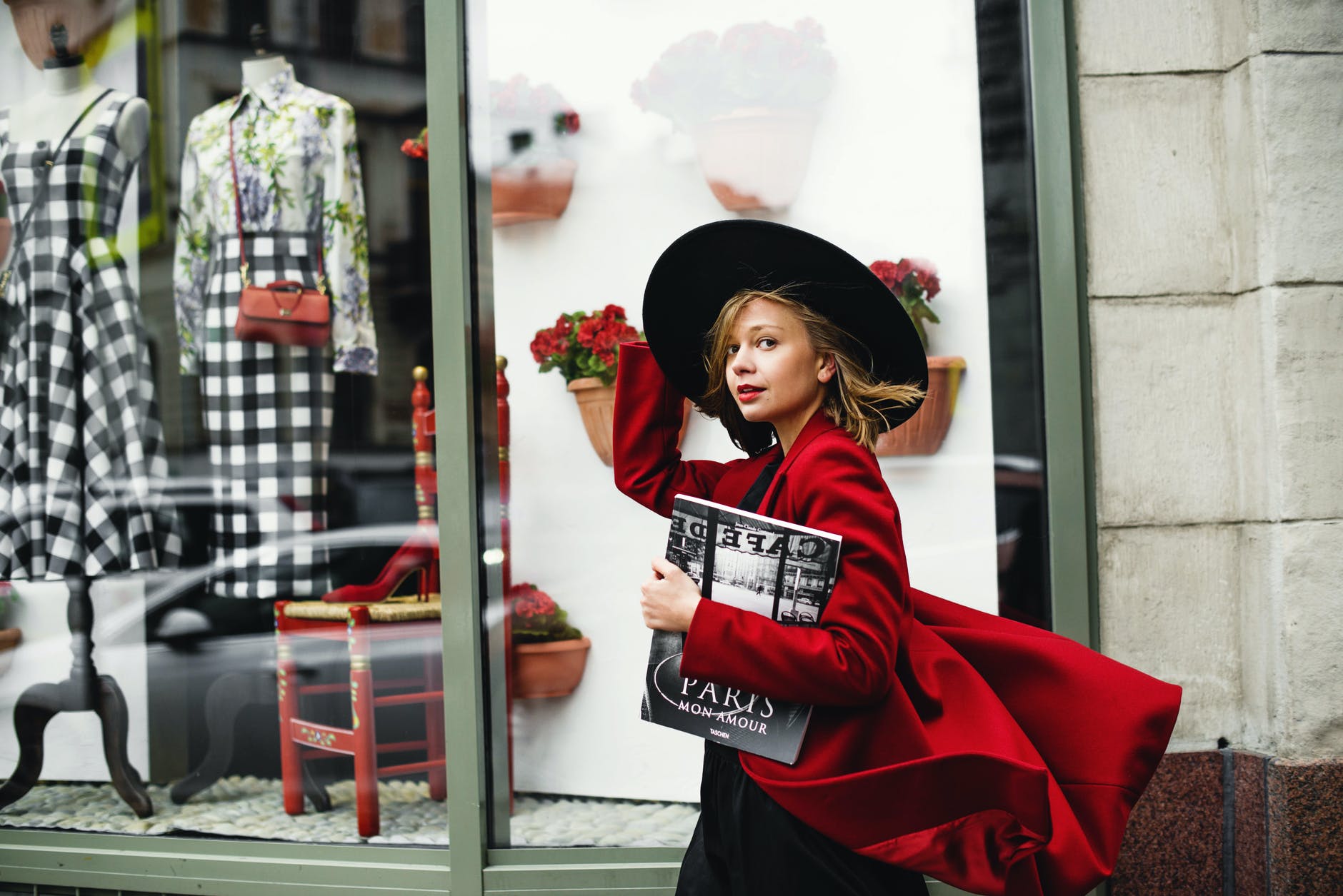 woman in red coat holding book