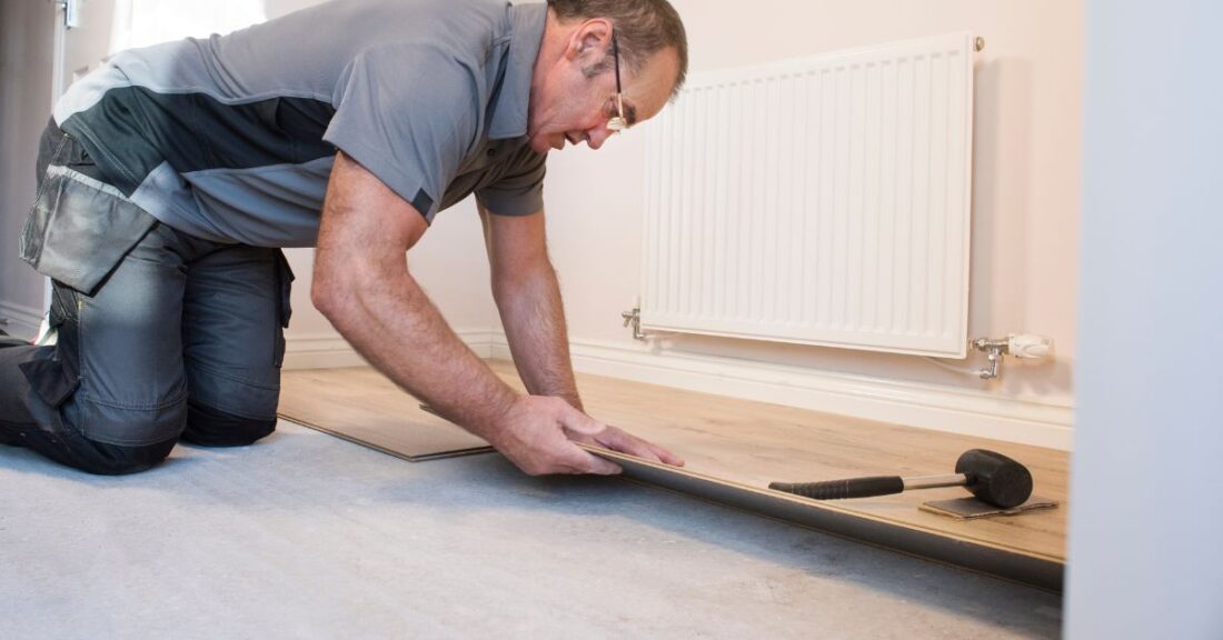 Working tradesman installs laminate floor